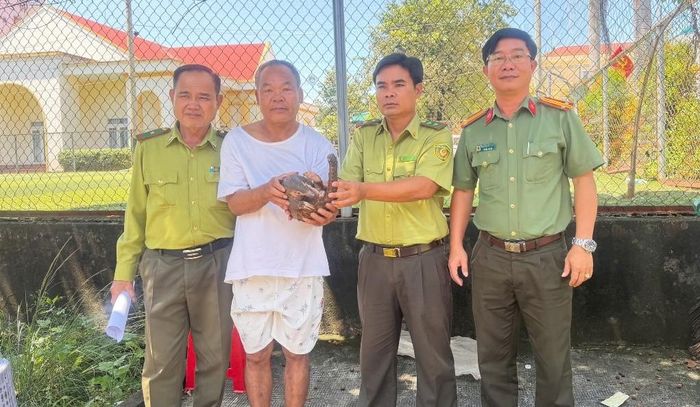 Ông Bùi Như Thỉ bàn giao cá thể tê tê Java cho lực lượng chức năng tiếp nhận, xử lý theo quy định. Ảnh: Công an TP Đồng Nai