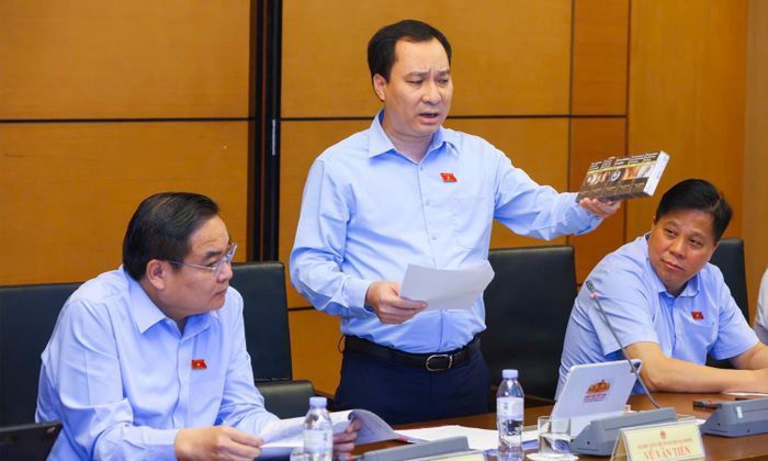 Đại biểu Vũ Văn Tiến đưa ra một số bao thuốc lá mang về từ Pháp để cho thấy các bao thuốc đều có cảnh báo kết hợp chữ với hình ảnh rất lớn ở cả mặt trước và mặt sau.