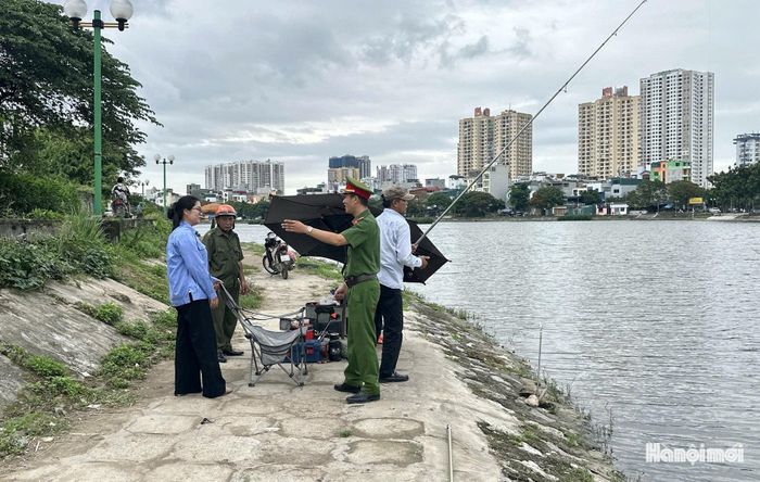 Lực lượng chức năng nhắc nhở các trường hợp cầu cá trái phép tại hồ Định Công. Ảnh: Thanh Tùng