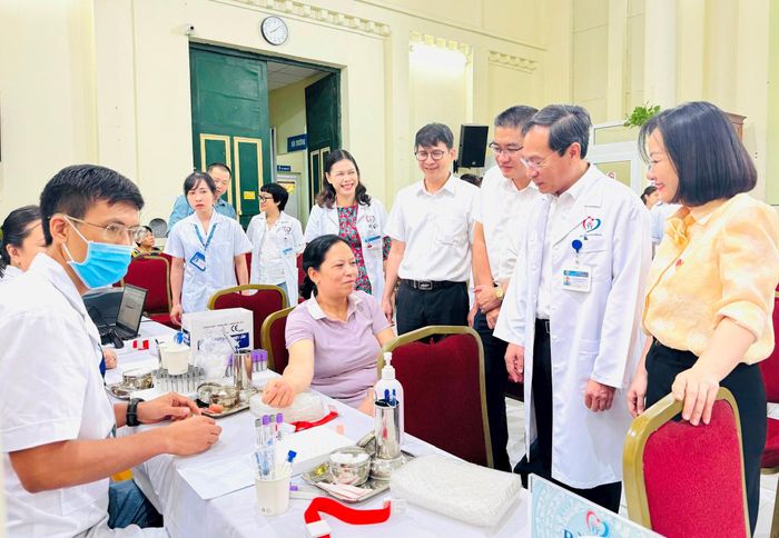 Lãnh đạo phường Kim Liên và Bệnh viện Đa khoa Đống Đa thăm hỏi, động viên người dân tại buổi khám sức khoẻ. Ảnh: NB