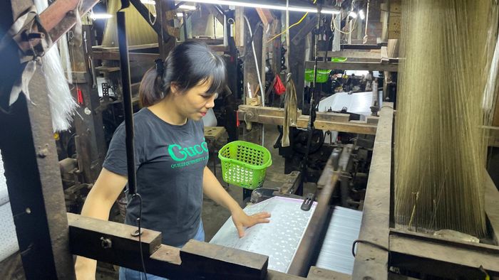 Thợ dệt làng Vạn Phúc miệt mài bên khung dệt, gìn giữ nét tinh hoa của sản phẩm lụa truyền thống. Ảnh: Việt Thắng