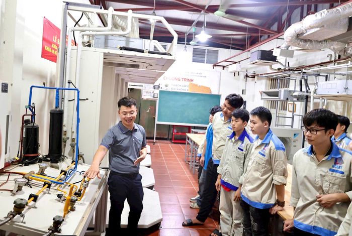 Chuyên viên Daikin hướng dẫn sinh viên tìm hiểu cấu tạo và nguyên lý hoạt động của hệ thống VRV tại xưởng thực hành. Ảnh: Trần Liên