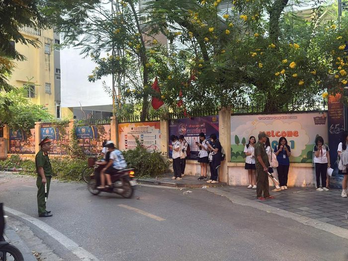 Tổ Cảnh sát trật tự và lực lượng an ninh cơ sở luôn có mặt tại khu vực cổng trường từ sớm, chủ động điều tiết giao thông thông suốt. Ảnh: Hoa Hiệp