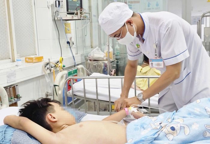 Nhân viên y tế chăm sóc cho bé trai 8 tuổi bị tổn thương phổi. Ảnh: Nguyễn Thuận.
