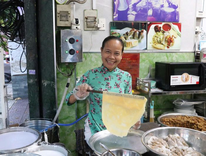  Bà Loan làm việc nhanh nhẹn, gọn gàng trong tà áo dài. Ảnh: Trang Thư. 