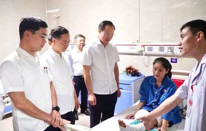Thứ trưởng Đoàn Trung Kiên và đoàn công tác nghe bác sĩ Bệnh viện Đa khoa Cửa Đông thông tin về phác đồ điều trị, phục hồi chức năng cho cô giáo Hoàng Thị Hiền. Ảnh: Hồ Lài
