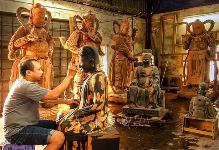 Người dân Sơn Đồng gìn giữ nghề chạm khắc tạc tượng truyền thống. Ảnh: Phương Anh-TTXVN