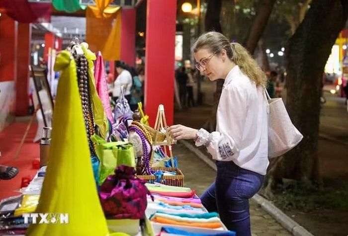 Du khách nước ngoài tham quan các sản phẩm tại gian trưng bày của làng lụa Vạn Phúc. Ảnh: Khánh Hòa/TTXVN