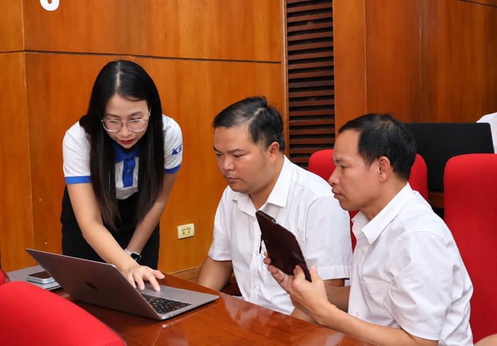 Kỹ thuật viên Công ty Cổ phần Đầu tư Kỷ nguyên mới Việt Nam hướng dẫn cán bộ, công chức xã, phường cài đặt ứng dụng “Trợ lý nhân dân”. Ảnh: Đồng Thúy - TTXVN