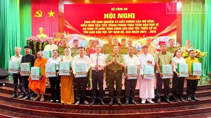 Lãnh đạo Bộ Công an và tỉnh Vĩnh Long trao quà cho những điển hình tiên tiến. (Ảnh: BÁ DŨNG)