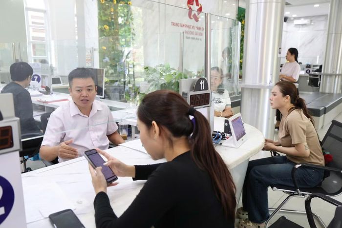  Anh Hà Minh Nhựt hướng dẫn người dân thực hiện thủ tục hành chính tại Trung tâm Phục vụ hành chính công phường Sài Gòn. (Ảnh: LÊ THOA) 