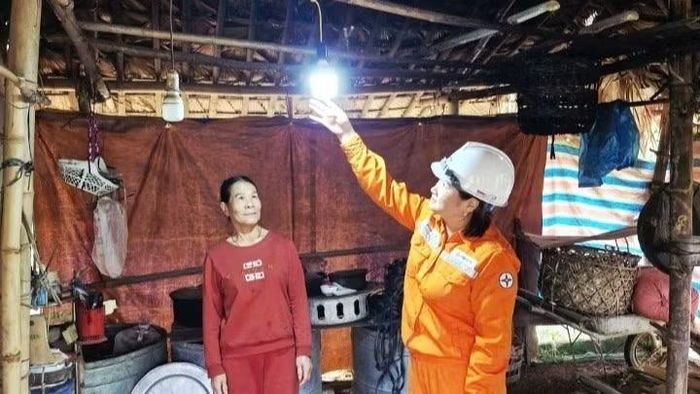 Nhân viên Điện lực Bắc Quang hỗ trợ người dân xã Đồng Tâm lắp đặt bóng đèn. (Ảnh: EVNNPC cung cấp)
