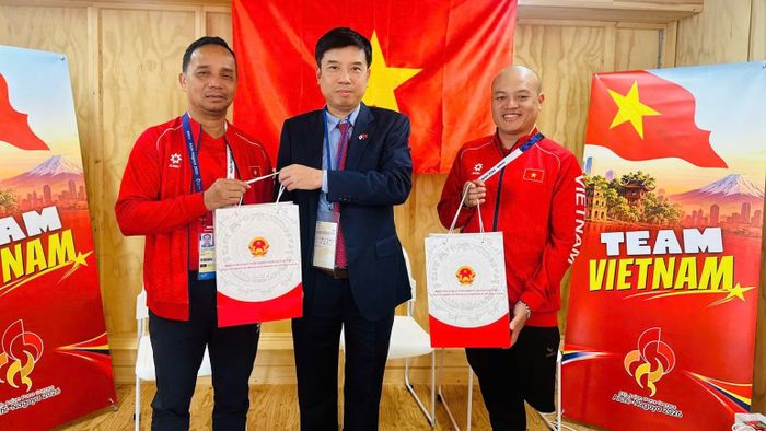 Phó Cục trưởng Thể dục thể thao Việt Nam, Trưởng Đoàn Thể thao người khuyết tật Việt Nam tại Asian Para Games 5 Nguyễn Trọng Hổ cùng đại diện Đội tuyển bóng bàn người khuyết tật Việt Nam nhận quà tặng từ Tổng Lãnh sự Việt Nam tại Osaka Nguyễn Trường Sơn. (Ảnh: ĐỨC TUYÊN)