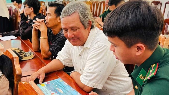 Cán bộ Đồn Biên phòng Tuy Hòa tuyên truyền ngư dân các quy định về chống khai thác IUU. (Ảnh: NGUYỄN LÂN)