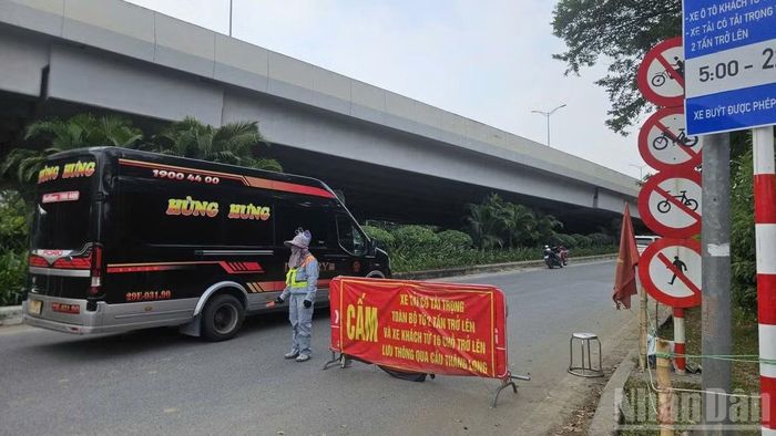Công nhân Công ty cổ phần Công trình giao thông 2 Hà Nội tham gia hướng dẫn phân luồng phương tiện nhằm giảm ùn tắc đoạn qua cầu Thăng Long.