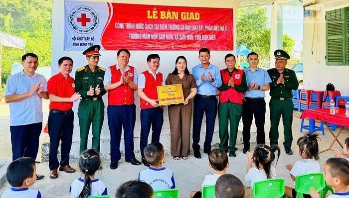 Các đơn vị tài trợ và chính quyền xã Sam Mứn chứng kiến bàn giao công trình nước sạch cho điểm Trường mầm non Ca Hâu. (Ảnh: LÊ LAN)