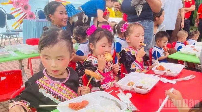 Học sinh điểm Trường mầm non Ca Hâu hân hoan khi được ăn bữa trưa do các cô, chú trong đoàn từ thiện tự tay nấu, chia phần cho từng cháu. (Ảnh: LÊ LAN)