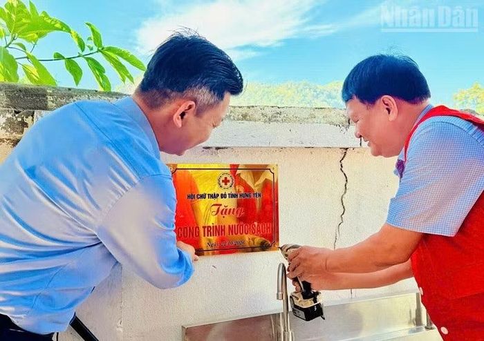 Lãnh đạo Hội Chữ thập đỏ tỉnh Điện Biên và lãnh đạo xã Sam Mứn gắn biển công trình nước sạch tặng Trường. (Ảnh: LÊ LAN)