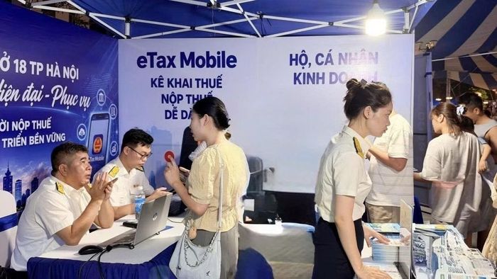 Công chức thuế Thành phố Hà Nội hướng dẫn người dân cài đặt, sử dụng eTax Mobil. (Nguồn ảnh: Cục Thuế)