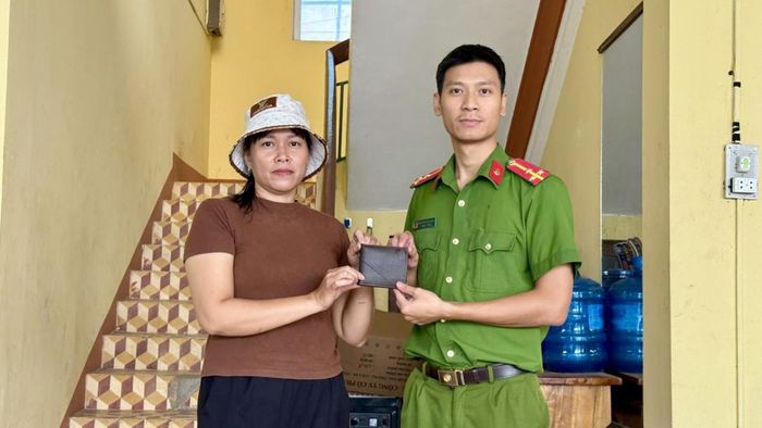 Chị Lan bàn giao tài sản nhặt được cho Công an xã.
