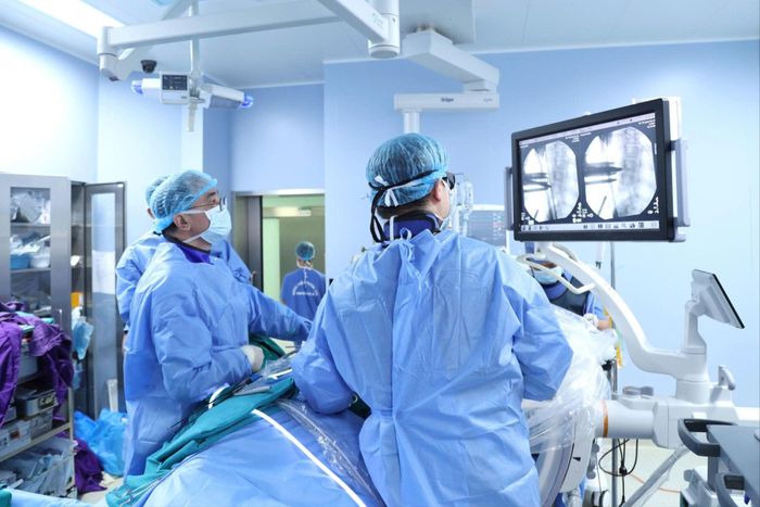  Ê-kíp bác sĩ thực hiện phẫu thuật chỉnh vẹo cột sống cho bệnh nhi. Ảnh: AN NGỌC 