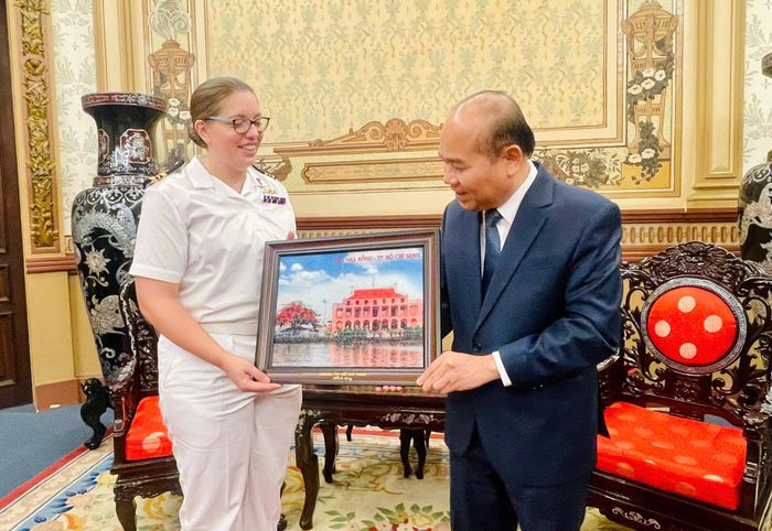 Phó Chủ tịch UBND TPHCM Trần Văn Bảy trao quà lưu niệm đến Trung tá Helen Taylor. Ảnh: PHƯƠNG NAM