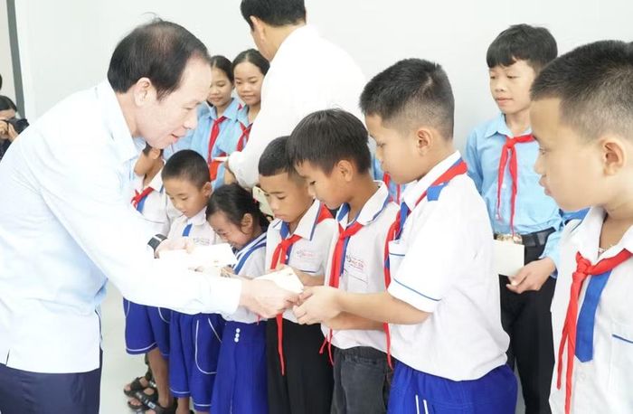 Phó Thủ tướng Lê Tiến Châu và lãnh đạo tỉnh Nghệ An tặng quà cho học sinh Trường Phổ thông nội trú liên cấp Tiểu học và Trung học cơ sở Anh Sơn. Ảnh: Hồ Lài