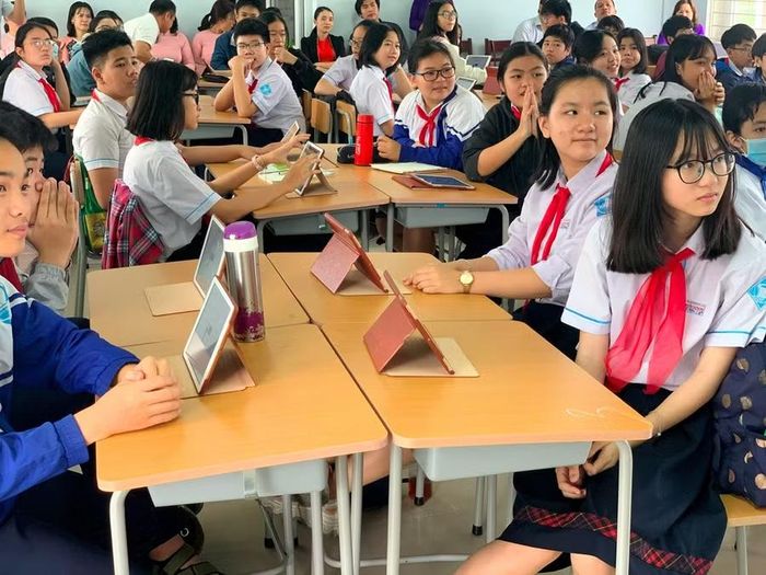 Học sinh Trường THCS Nguyễn Tri Phương trong 1 giờ học tiếng Anh tại phòng học thông minh, kết hợp dùng máy tính bảng và tương tác với giáo viên qua máy chiếu đa lập thể.