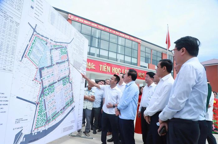 Phó Thủ tướng Lê Tiến Châu nghe báo cáo về tiến độ xây dựng các hạng mục trong Trường Phổ thông nội trú liên cấp tiểu học và trung học cơ sở Anh Sơn (Ảnh: Ngô Toàn)