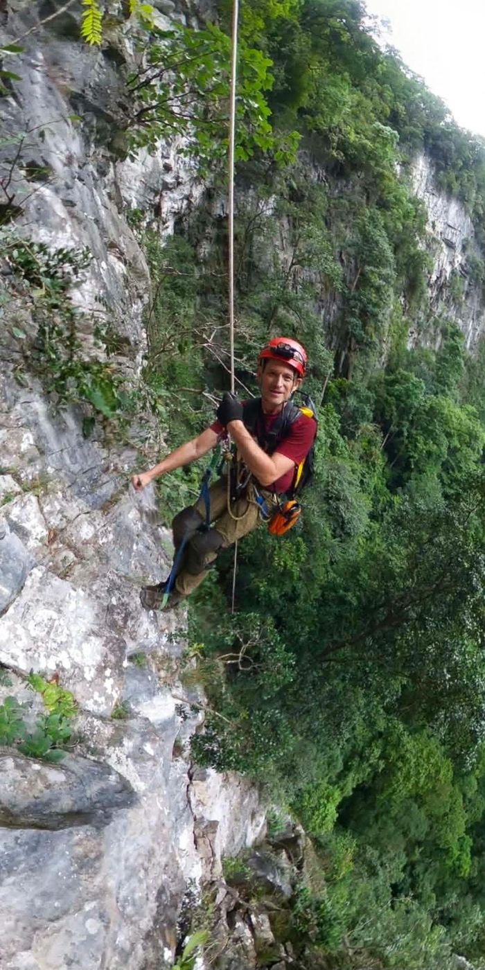 Thành viên đoàn thám hiểm đu dây xuống vách đá để tiếp cận, khảo sát và đo đạc hố sụt. (Ảnh: Jungle Boss)