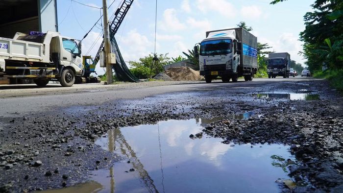 Tại một số vị trí, nhiều 'ổ gà, ổ voi' nằm giữa lòng đường QL80, gây khó khăn và nguy hiểm cho người và phương tiện đi qua, đặc biệt với xe máy.