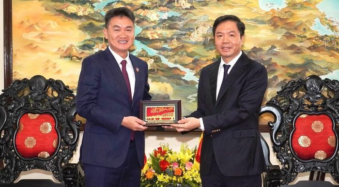 Phó Bí thư Thường trực Thành ủy Huế (bìa phải) tặng quà lưu niệm đến Bí thư Ban Chấp hành Trung ương Đoàn Thanh niên Nhân dân Cách mạng Lào Thongly Sisoulith. Ảnh: Minh Nguyên