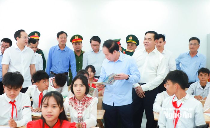 Phó Thủ tướng Lê Tiến Châu kiểm tra sách, trò chuyện cùng các cháu học sinh Trường Phổ thông nội trú liên cấp Tiểu học và Trung học cơ sở Môn Sơn. Ảnh: Thành Duy