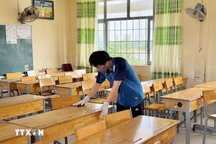 Giáo viên Trường THCS Hai Bà Trưng, xã Hiệp Phước vệ sinh, khử khuẩn lớp học sau khi ghi nhận 4 ca mắc não mô cầu. (Ảnh: Đinh Hằng/TTXVN)