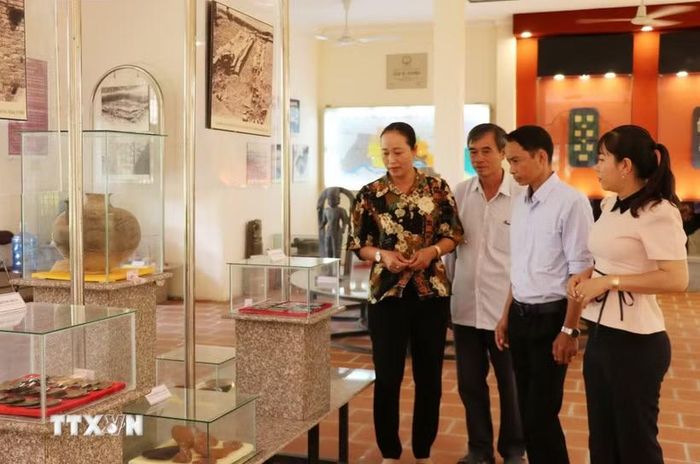 Du khách xem hiện vật của nền văn hóa Óc Eo tại Di tích lịch sử-văn hóa cấp quốc gia Gò Thành ở xã Tân Thuận Bình, tỉnh Đồng Tháp. (Ảnh: Hữu Chí/TTXVN)