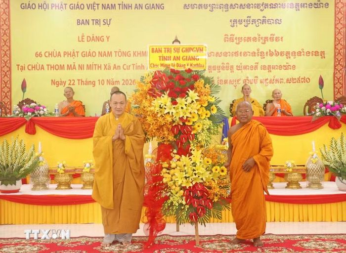 Thượng tọa Thích Viên Quang (trái), Uỷ viên Hội đồng Trị sự Giáo hội Phật giáo Việt Nam, Phó Trưởng Ban Trị sự Giáo hội Phật giáo Việt Nam tỉnh An Giang, tặng hoa chúc mừng lễ Dâng y Kathina của đồng bào Khmer tại chùa Thơ Mít, xã An Cư, tỉnh An Giang. (Ảnh: Công Mạo/TTXVN)