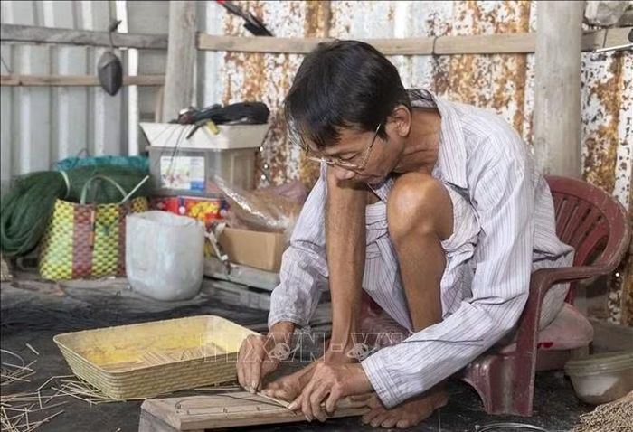 Ông Nguyễn Văn Tôn (ngụ ấp Cần Thới, xã Cần Đăng, tỉnh An Giang) tỉ mỉ đan từng chiếc hom tre sau đó ráp vào chiếc lợp lươn.