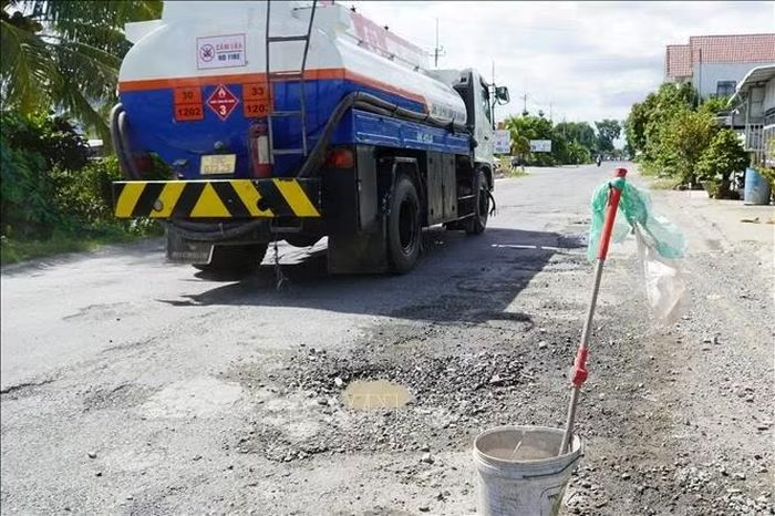 Người dân xã Hòa Điền đặt vật dụng cảnh báo ổ gà, ổ voi trên Quốc lộ 80.