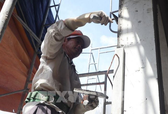 Nhà thầu đang đẩy nhanh triển khai xây tô bên trong và bên ngoài khối nhà chính. Ảnh: Tuấn Phi - TTXVN