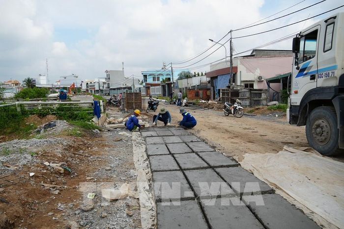Thi công dự án đường giao thông hai bên bờ sông Bảo Định. Ảnh: Công Trí - TTXVN