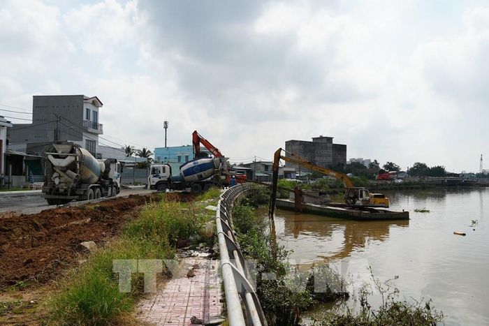 Thi công hạng mục kè, cầu và đường giao thông Dự án đường giao thông hai bên bờ sông Bảo Định. Ảnh: Công Trí - TTXVN