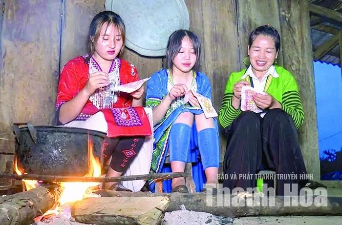 Chị Hơ Thị Dua (mặc áo xanh, bên phải) hướng dẫn các thiếu nữ dân tộc Mông thêu hoa văn trên váy.