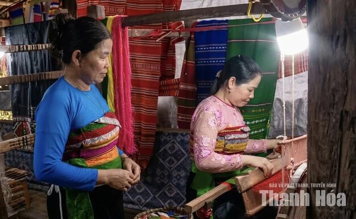 Bà Hà Thị Tân - Tổ trưởng Tổ dệt Piềng Pheo (mặc áo xanh) hướng dẫn chị em kỹ thuật phối màu và dệt hoa văn thổ cẩm Thái.