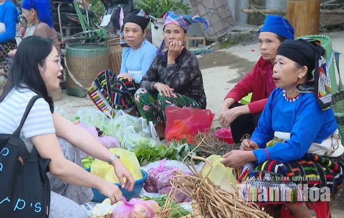 Du khách trò chuyện cùng người bán hàng tại chợ Ngàm Pốc.