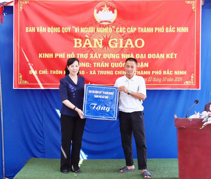  Trong chương trình bàn giao kinh phí hỗ trợ xây dựng nhà Đại đoàn kết, đồng chí Nguyễn Thị Hà trao quà cho gia đình ông Trần Quốc Thuận. 