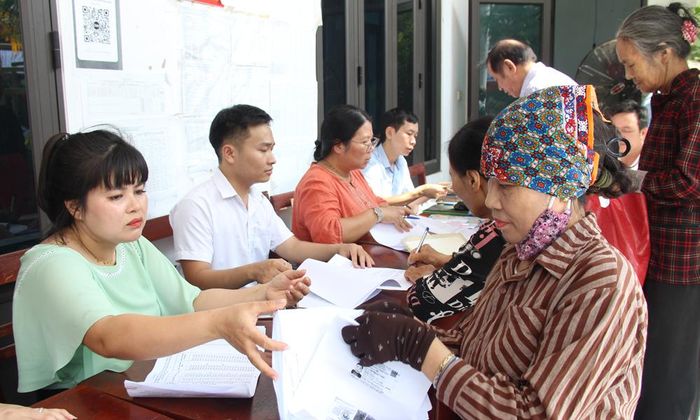 Cán bộ chi nhánh Trung tâm phát triển quỹ đất Bắc Giang hướng dẫn người dân làm thủ tục nhận tiền bồi thường.