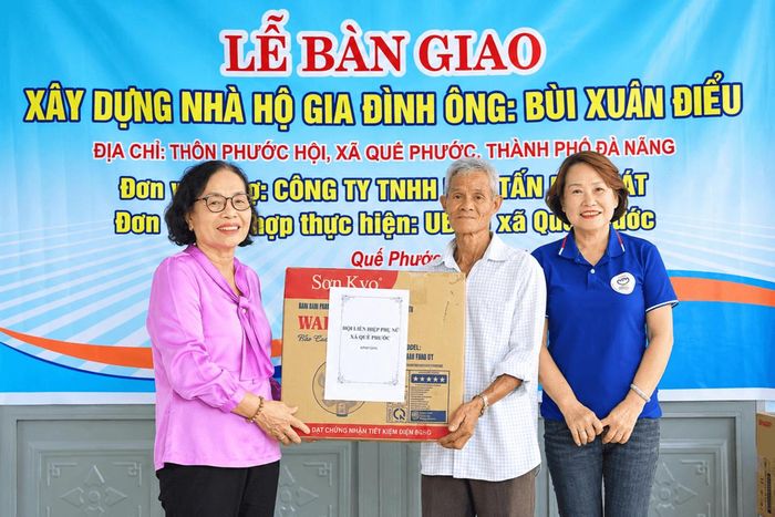 Bà Tám (áo tím) trao hỗ trợ cho gia đình có hoàn cảnh khó khăn. Ảnh do nhân vật cung cấp