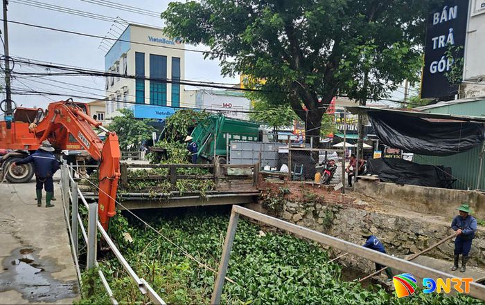 Công nhân Công ty CP Môi trường đô thị Quảng Nam khơi thông dòng chảy tại mương thoát nước cầu Ngân Hàng (phường Tam Kỳ). Ảnh: HỒ QUÂN
