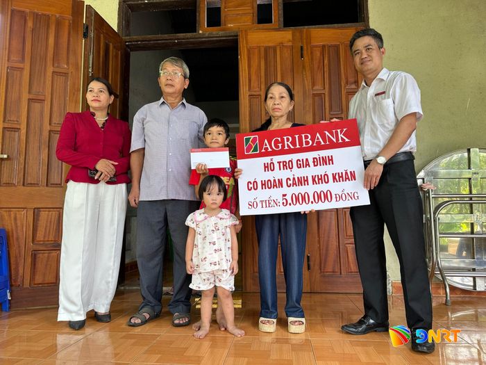 Đại diện Agribank chi nhánh Bắc Trà My Quảng Nam trao quà động viên gia đình vượt qua khó khăn. Ảnh: ĐĂNG NGUYÊN