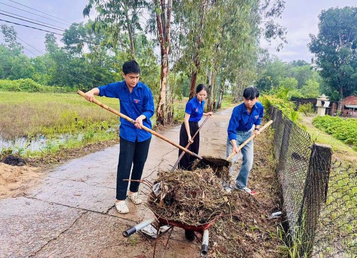 Thanh niên xã Thăng An dọn dẹp vệ sinh môi trường để thi công công trình. Ảnh: ĐVCC